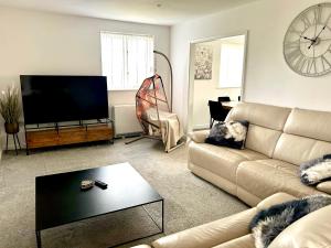 a living room with a couch and a flat screen tv at Idyllic location, Amazing view, Spacious in Marazion