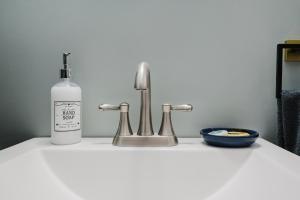 a bottle of soap sitting next to a sink at Sr Pilot Earhart Hangar Suite, 2 br K &Q, 1 Ba in Atchison +57 photos