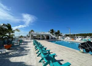 a row of blue lounge chairs next to a swimming pool at Mi mini mundo verde in Key Largo