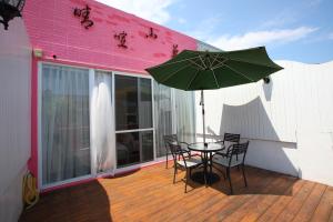 a patio with a table and chairs and an umbrella at Qing Noise Villas in Hualien City