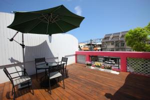a patio with a table and chairs and an umbrella at Qing Noise Villas in Hualien City