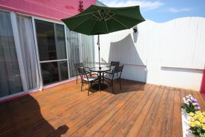 a patio with a table and chairs and an umbrella at Qing Noise Villas in Hualien City