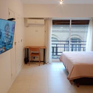 Un dormitorio con una cama y una mesa y una ventana. en Excelente departamento céntrico cerca de todo, en Buenos Aires 18 fotos más