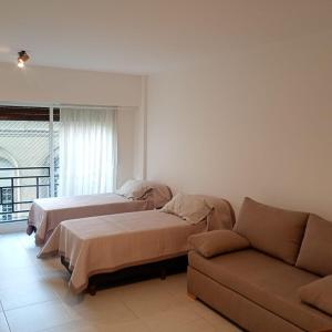 Una sala de estar con dos camas y un sofá en Excelente departamento céntrico cerca de todo, en Buenos Aires