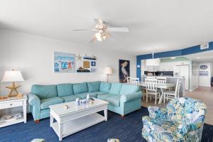 マートルビーチにあるOceanfront Views with 7 Beds, Pools, Lazy River, Gym by myBeach Vacation Rentalsの青いソファとキッチンのあるリビングルーム