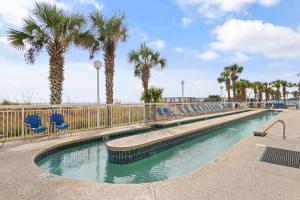 マートルビーチにあるOceanfront Views with 7 Beds, Pools, Lazy River, Gym by myBeach Vacation Rentalsのヤシの木と青い椅子が備わるスイミングプール