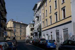 een straat met auto's aan de kant van de weg bij Casa di Franco Navigli in Milaan
