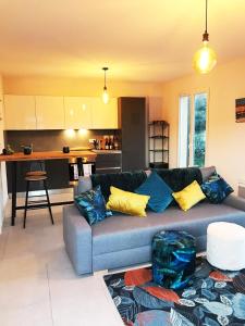 普朗德拉图尔Maison Jasmin, Modern, air-conditioned 2-bed with lovely terrace & communal pool的客厅里有一张沙发和一个厨房