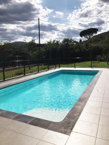 普朗德拉图尔Maison Jasmin, Modern, air-conditioned 2-bed with lovely terrace & communal pool的院子里有一个蓝色水的游泳池