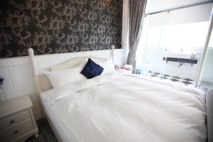 a large white bed in a room with a window at Qing Noise Villas in Hualien City