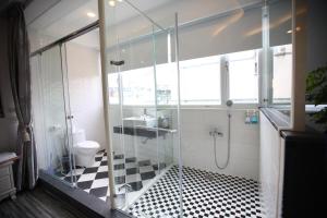 a bathroom with a glass shower and a toilet at Qing Noise Villas in Hualien City
