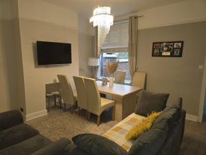 a living room with a couch and a dining room table at Tomelle Manchester in Manchester