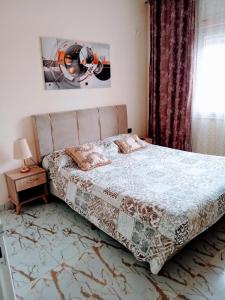 a bedroom with a bed and a table and a window at Sousse appartement sahloul in Sousse