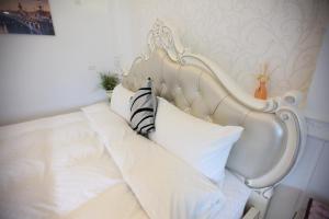 a white bed with a white headboard and pillows at Qing Noise Villas in Hualien City