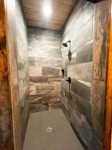 Un baño con ducha con pared de piedra. en The Cozy Endless Sunset Cabin!, en Broken Bow 40 fotos más