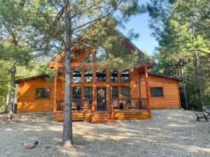 Cabaña de madera grande con ventana grande en The Cozy Endless Sunset Cabin!, en Broken Bow