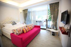 a living room with a pink couch and a bedroom at Qing Noise Villas in Hualien City