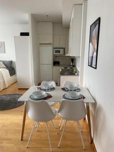 a white table with four chairs and a kitchen at Kodikas huoneisto Rovaniemen keskustassa in Rovaniemi