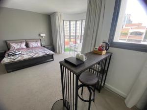 Dinar - cozy master bedroom في أبوظبي: غرفة نوم بها سرير وطاولة وكرسي +24 صورة