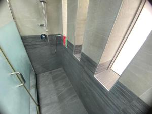 Dinar - cozy master bedroom في أبوظبي: حمام مع دش وباب زجاجي