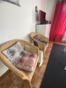 salon z 2 wiklinowymi krzesłami i telewizorem w obiekcie Résidence Les Gemeaux I - Appartement trois pièces au coeur du village MAE-2304 w mieście Villard-de-Lans
