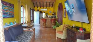 a living room with yellow walls and a couch at Villas del Amor Amor in Puerto Vallarta