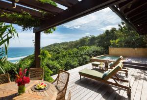 um deque com uma mesa e cadeiras e o oceano em Royal Isabela em Isabela