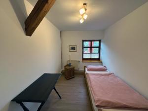 a room with two beds and a table in it at Lassen Hof Ferienwohnung 01 Bienenstock in Brodersby +12 photos