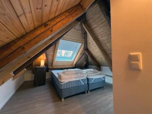 an attic room with two beds and a window at Lassen Hof Ferienwohnung 01 Bienenstock in Brodersby
