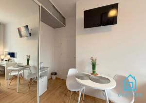 a dining room with two tables and a tv on the wall at Paris Room Old Town Gdansk in Gdańsk