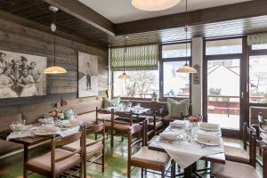 a dining room with tables and chairs and windows at Hotel Alpenhof Postillion in Kochel