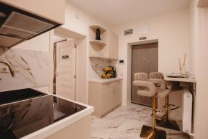 a kitchen with a counter and two chairs in it at Eden Central Boutique Suites - Garden & Spacious Apartments in Cluj-Napoca +221 photos
