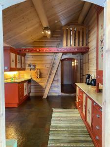 a large kitchen with a staircase in a log cabin at Kvenahytta in Markegardlian