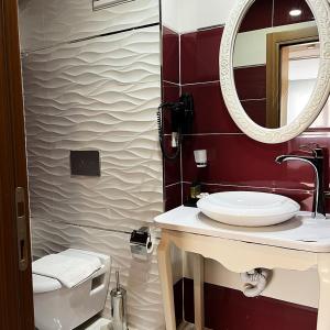 a bathroom with a sink and a toilet and a mirror at Elite Marmara Bosphorus & Suites in Istanbul