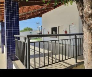 a balcony with a black railing and a tree at Apartamento aconchegante in Teresina