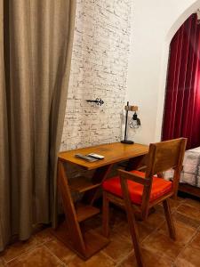a wooden desk with a chair and a bed at L'orée du bois in Mbala