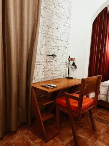 a wooden desk with a chair next to a bed at L'orée du bois in Mbala