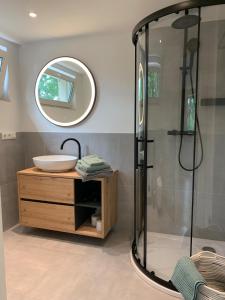 Un baño con ducha, lavabo y espejo. en Auszeit am Schwielowsee - Exklusiver Bungalow mit Seeblick, en Schwielowsee
