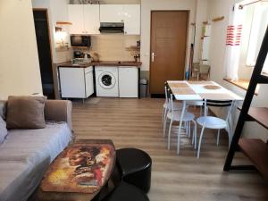 a living room with a couch and a table and a kitchen at Résidence Rue De La Paix - T2 PLEIN CENTRE VILLAGE MAE-3731 in Villard-de-Lans +2 photos