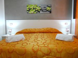 トラーパニにあるLe casette del generaleのベッドルーム1室(大きなオレンジ色のベッド1台、ランプ2つ付)