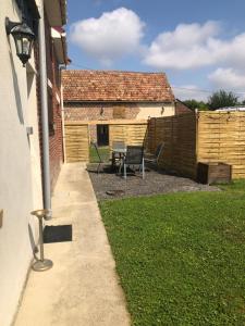 a backyard with a table and a fence at Maison de campagne in Hamelet +6 photos
