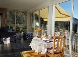 Habitación con mesa, sillas y balcón. en villa des oliviers, en Le Tignet