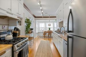 a kitchen with white cabinets and a stainless steel refrigerator at - King Bed - Massive Yard - Fully Equipped Condo in Geneva