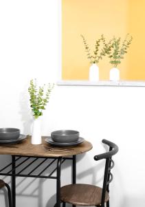 a table and chairs with plates and plants on it at Relaxx - 3Brighton Beach - Green3057 in Brooklyn