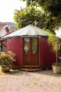 a red tent with a tarp on top of it at Nômades Vibe da Ilha - Adventure Hostels in Florianópolis