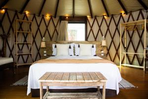 een slaapkamer met een groot bed en een houten tafel bij Nômades Vibe da Ilha - Adventure Hostels in Florianópolis +45 foto's