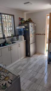 a kitchen with a stainless steel refrigerator and white cabinets at Casa Playa Loreto, familiar, ubicada a 120 metros de la playa, con maravillosa vista al mar, cercano a Caldera in Caldera +10 photos