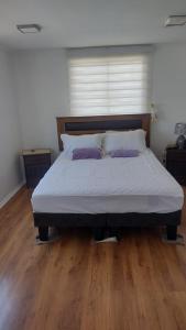 a bed with two pillows on it in a bedroom at Casa Playa Loreto, familiar, ubicada a 120 metros de la playa, con maravillosa vista al mar, cercano a Caldera in Caldera