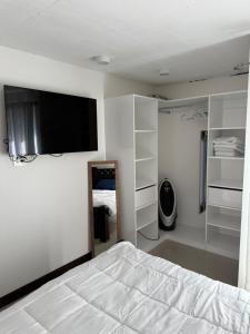 a bedroom with a bed and a flat screen tv at Khaya Curridabat in Curridabat