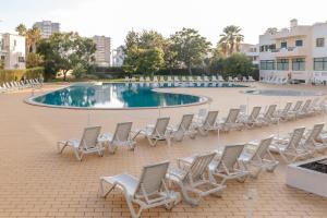 a group of chairs and a swimming pool at Dunas Pool View by MyLokals in Alvor